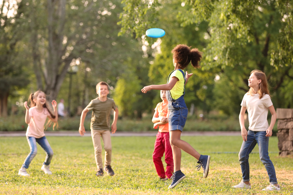 Preschool kid boy in colorful clothes playing outdoors during